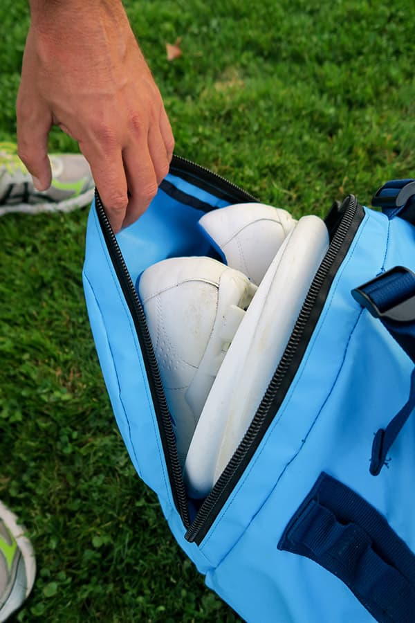 hand met zijvak op lichtblauwe waterdichte tas
