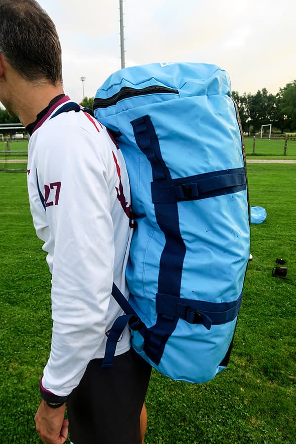 man met blauwe waterdichte tas op zijn rug