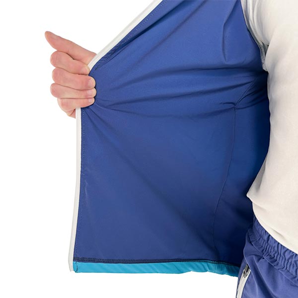torso of a man wearing a sublimated blue jacket and holding the zipper with his hand