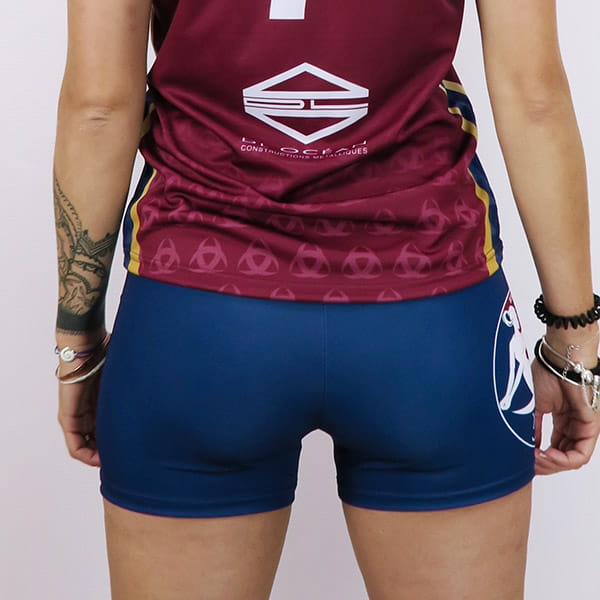 bas du corps d'une femme de dos portant un shorty de volley-ball